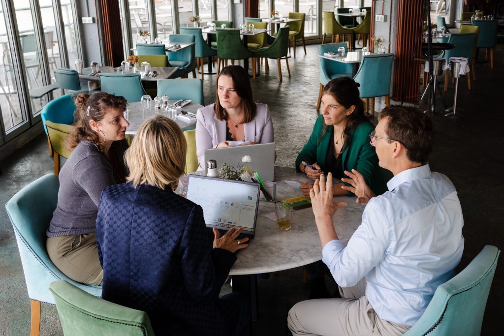 5 personnes assises autour d'une table en séminaire